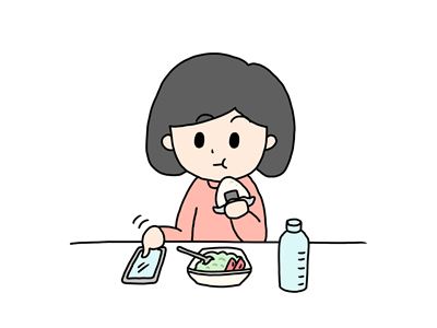 スマートフォンを操作しながら食事をする女の子